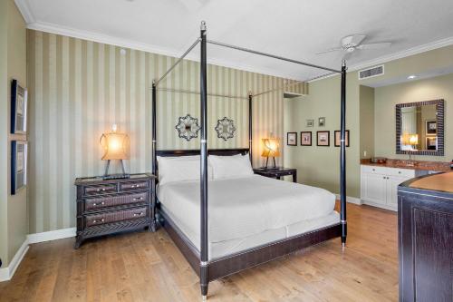 a bedroom with a four poster bed and two night stands at Penthouse Paradise in Siesta Key