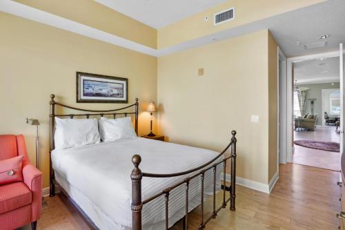 a bedroom with a bed and a red chair at Penthouse Paradise in Siesta Key
