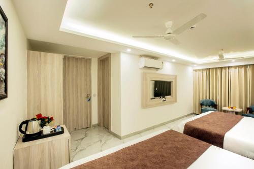 a hotel room with two beds and a television at Hotel East End Delhi Aiport in New Delhi