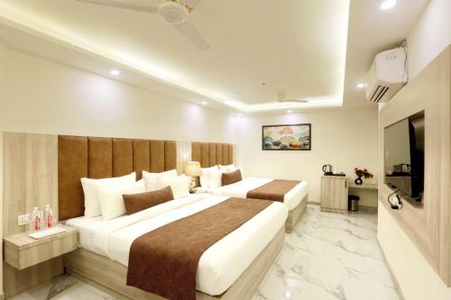 a hotel room with two beds and a television at Hotel East End Delhi Aiport in New Delhi