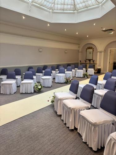 a large room with white tables and blue chairs at Best Western Lamphey Court Hotel and Spa in Lamphey