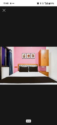 una camera da letto con un letto e una parete rosa di Buddha Stay Inn a Varanasi