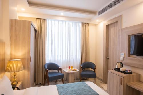a hotel room with a bed and a table and chairs at Hotel East End Delhi Aiport in New Delhi