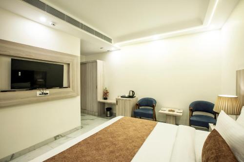 a hotel room with a bed and a flat screen tv at Hotel East End Delhi Aiport in New Delhi