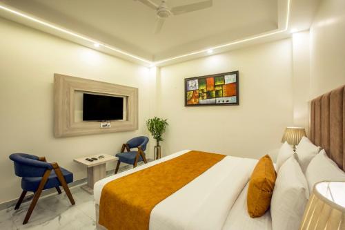 a hotel room with a bed and a tv at Hotel East End Delhi Aiport in New Delhi