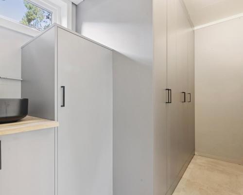 a white kitchen with white cabinets and a window at Ringåsen in Berg