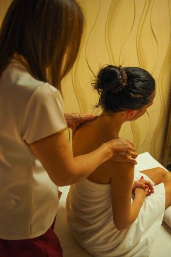a woman standing next to a woman sitting on a bed at Prezident Luxury Spa & Wellness Hotel in Karlovy Vary