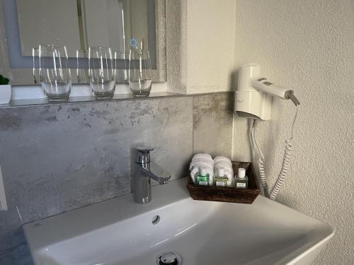 a bathroom sink with a soap dispenser and wine glasses at Ferienwohnungen St Marien in Gengenbach