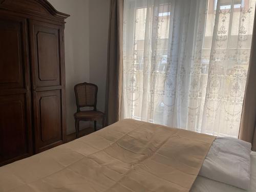 a bedroom with a bed and a window with a chair at Ferienwohnungen St Marien in Gengenbach