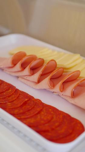 two hot dogs on a plate with cheese and sauce at Villa Recanto do Mar - Icaraizinho de Amontada in Amontada
