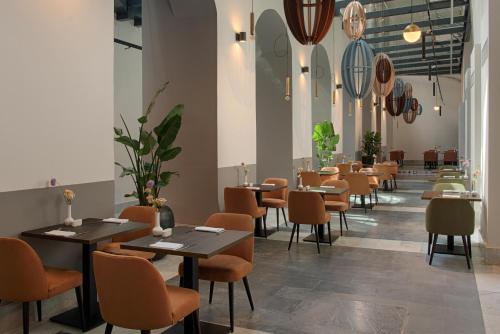 a restaurant with tables and chairs in a room at NH Collection Palermo Palazzo Sitano in Palermo