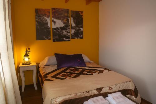 a bedroom with a bed and a table with a lamp at Tem Kotenkesh Depto Andiperlas x 4 pax in El Calafate