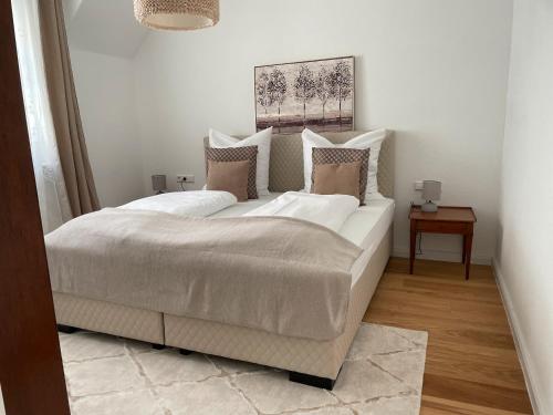 a bedroom with a large bed with white sheets and pillows at Ferienwohnungen St Marien in Gengenbach