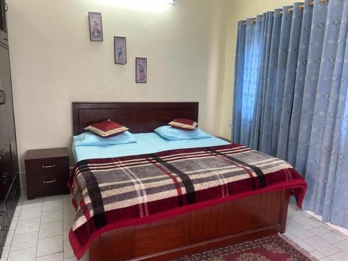 a bedroom with a bed with a plaid blanket at Hotel Gagandeep regency in Haldwāni