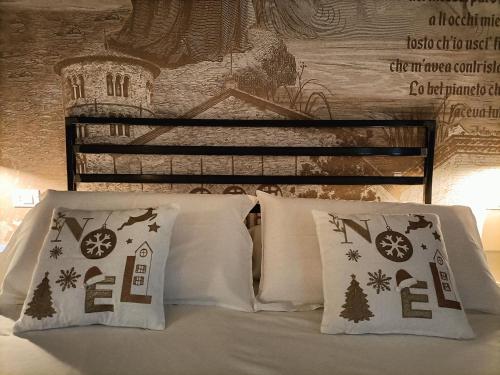 a bed with two pillows and a sign on the wall at BB LETTERARIO in Ravenna