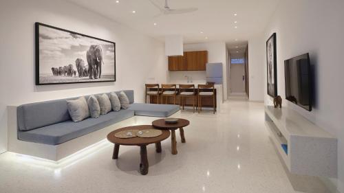 a living room with a blue couch and a table at One Ocean Hotel Apartments by Nest & Nomad in Msambweni