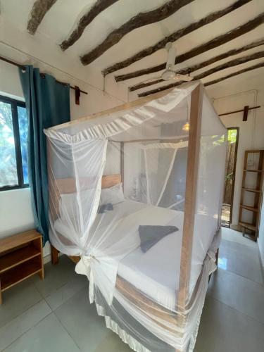 a bedroom with a canopy bed in a room at Zanzibar beach escape 1&2 in Bwejuu