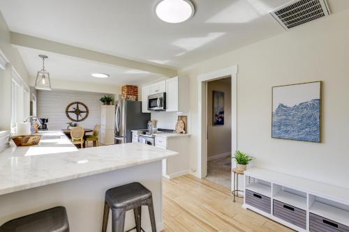 a kitchen and living room with white cabinets and a counter at Walk to Dtwn Camas! Updated Home with Game Room in Camas