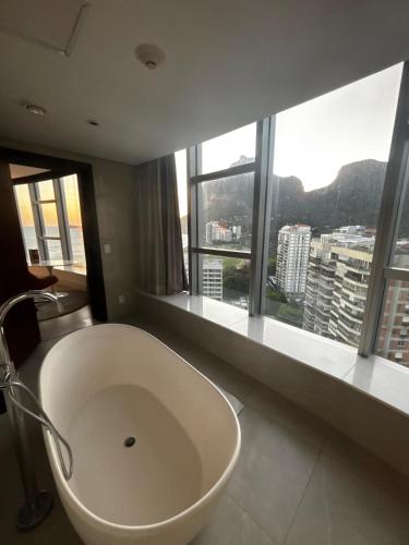 a bathroom with a large tub in front of a window at Luxuoso Hotel Nacional - Suíte com Banheira in Rio de Janeiro