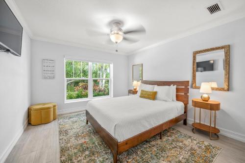 una camera da letto bianca con un letto e uno specchio di No Bad Daze a Palma Sola Park