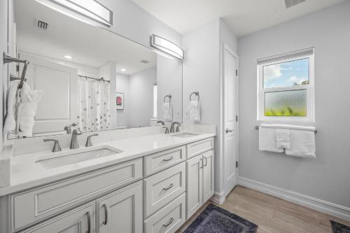 un bagno bianco con due lavandini e una finestra di No Bad Daze a Palma Sola Park