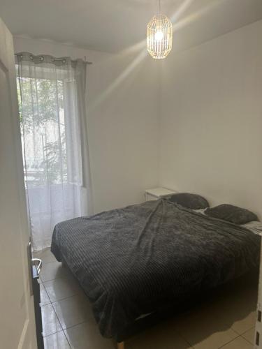 un dormitorio con una cama y una ventana en Chambre d hotes Marseille Prado, en Marsella