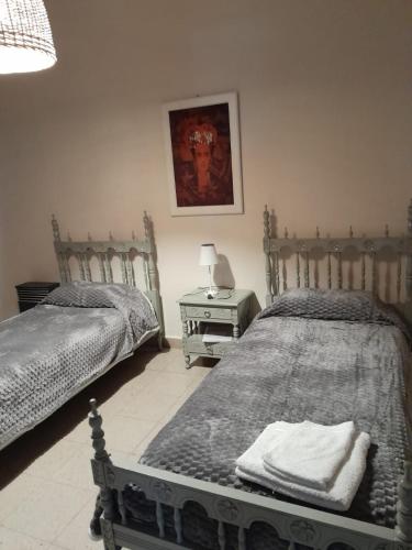 ein Schlafzimmer mit zwei Betten und einem Tisch mit Lampe in der Unterkunft Casa Zárate in Cordoba