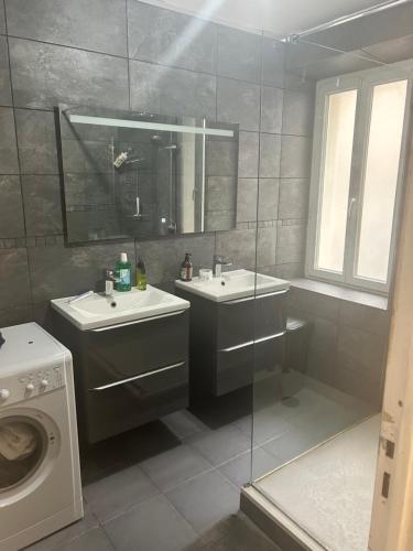Un baño con dos lavabos y lavadora. en Chambre d hotes Marseille Prado, en Marsella