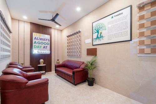 a waiting room with a couch and a sign at Treebo Dunag in Coimbatore