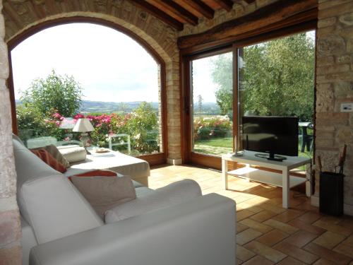 托迪Agriturismo La Torraccia的客厅里有一张白色的沙发和一扇大窗户