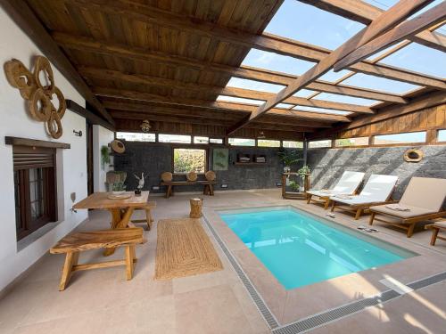 un patio al aire libre con piscina, mesa y sillas en Casita Oyala, en San Bartolomé