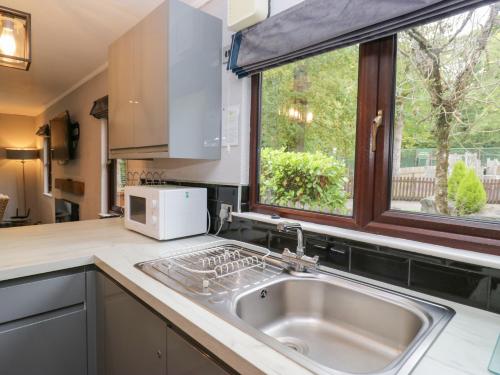 a kitchen with a sink and a window at Costapacket in Troutbeck Bridge