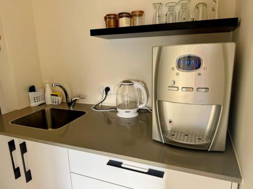 un comptoir de cuisine avec un micro-ondes et un évier dans l'établissement סוויטת ארגמן, à Beʼer Ora