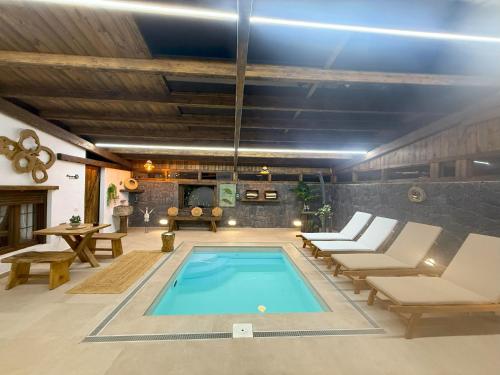 una piscina en una habitación con sillas y mesa en Casita Oyala, en San Bartolomé