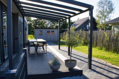 a patio with a table and a wooden deck at Ferienhaus Aurora, Sauna, familienfreundlich, angeln in Twist