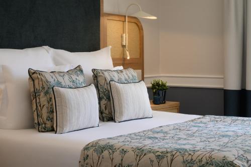 a hotel room with a bed with four pillows at M'AR De AR Muralhas in Évora