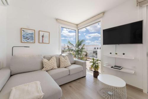 a white living room with a couch and a large window at CoastLight Rooftop by Bayside Modern Penthouse in Playa Honda