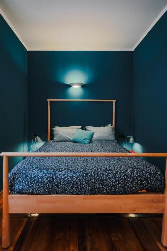 a bedroom with a bed with a blue wall at Appartamento in centro storico La Corte in Domodossola