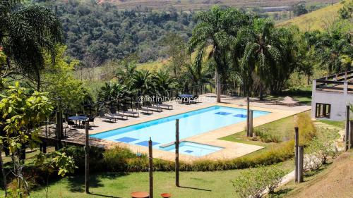an outdoor swimming pool with chairs and a resort at Igaratá: refúgio em meio a natureza com piscina in Igaratá