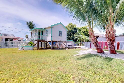 una casa con una palmera en un patio en DV #1 at DV Cabanas - Gold Standard Certified, en Caye Caulker