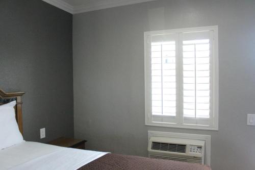 a bedroom with a bed and a window at Town House Motel in Lynwood