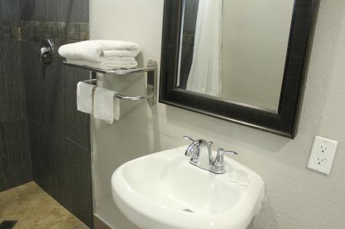 a bathroom with a sink and a mirror and towels at Town House Motel in Lynwood