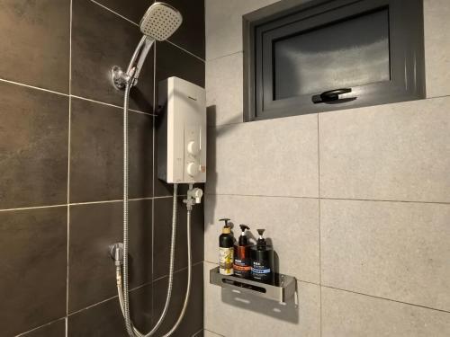 a shower in a bathroom with a shower head at Summer Cozy Studio Room in Perai