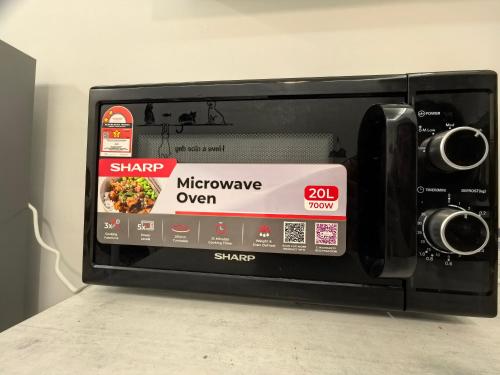 a microwave oven with a box inside of it at Summer Cozy Studio Room in Perai