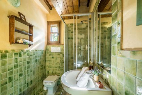 a bathroom with a tub and a toilet and a sink at Villa i Colli in Montaione