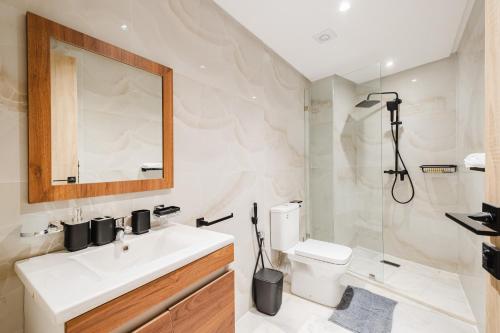 a bathroom with a sink and a toilet and a mirror at NEW Apartment Central 1BR-Queensize, AC&Terrace in Marrakech