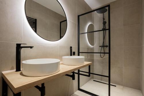 a bathroom with two sinks and a mirror at Bosvilla Lariks met sauna en hottub | 6 personen - Vakantiepark De Kremmer in Gasselte