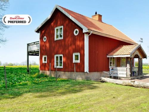 a red barn sitting in a field of grass at Lakeview Cottage Retreat-By Traum in Gränna