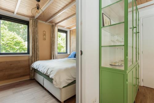 a bedroom with a green cabinet and a bed at Bungalow Bosuil | 2 personen - Vakantiepark De Kremmer in Gasselte