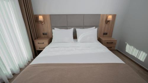 a bedroom with a large white bed with white pillows at Altındere Vadi Hotel in Akyazı